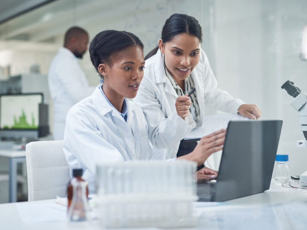 two scientists looking at a laptop